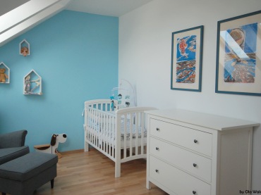 Do błękitnego pokoju dziecięcego dobrano białe meble. Nad komodą zawieszono dwa ciekawe obrazy, które dekorują wnętrze...