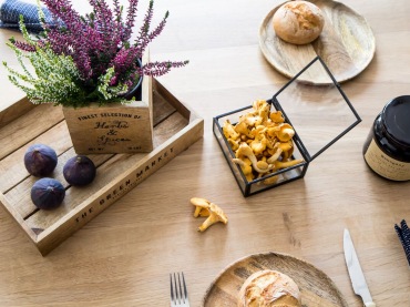 Na stole w jadalni znajdują się jesienne dekoracje. Wrzosy i grzyby oraz drewniane tacki tworzą klimatyczną kompozycję.