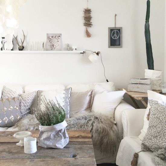 Dekoracja białych sof poduszkami w salonie