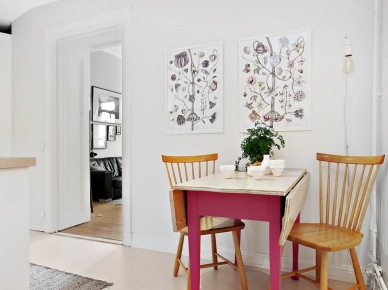 Botaniczne plakaty, różowy stół z drewnianym blatem i żarówka na kablu w dekoracji kuchni (25922)
