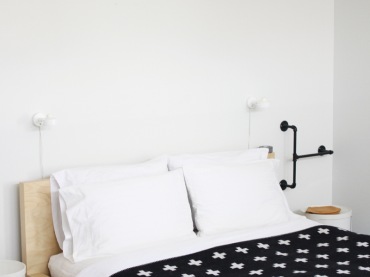 Drewniane łóżko,pasiasty dywan,czarna narzuta w białe gwiazdki (21399)