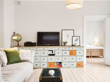 Turkusowo-miodowe szuflady w komodzie,skandynawskie grafiki,granatowy kufer stolik i biała sofa z zielonymi poduszkami (27739)