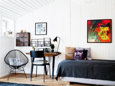Nowoczesny kolorowy obraz na ścianie z białych paneli,ażurowy czarny fotel acapulco,czarna narzuta i czarne krzesło przy rustykalnym biurku z grubym drewnianym blatem (27694)