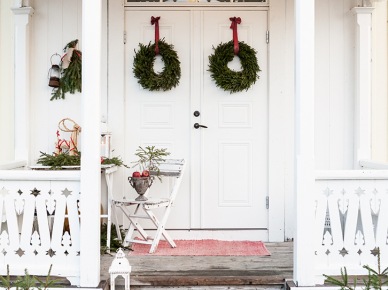 Zielone wianki świąteczne na czerwonych wstążkach jako dekoracja drzwi wejściowych do domu,dekoracja świąteczna małego tarasu przed domem (47941)