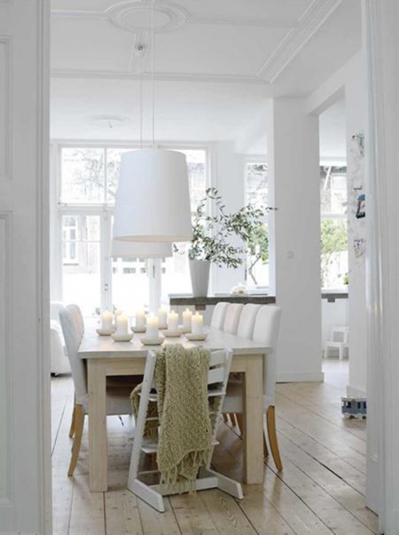 Drewniany stół w białej , skandynawskiej jadalni