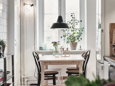 Mała i przytulna jadalnia czerpie z naturalnego skandynawskiego stylu. We wnętrzu dominuje biel, którą urozmaicają wyraziste akcenty czerni, np. w postaci lampy wiszącej czy krzeseł. Zielone rośliny potęgują urok...