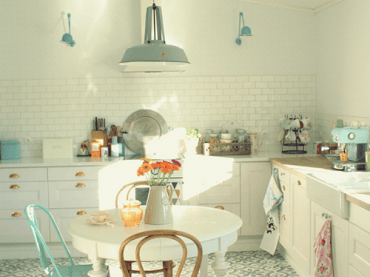sympatyczna, miła i słoneczna kuchnia pełna turkusowych dodatków - białe ściany i meble kuchenne wygladają estetycznie...