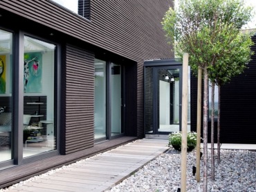 duński dom w nowoczesnej, czarnej bryle ujmuje geometrią, estetyką i czarnym dizajnem - duże ściany w szkle nadają mu...