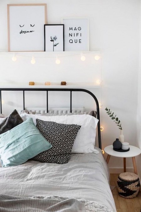 Czarna rama łóżka w aranżacji pastelowej sypialni