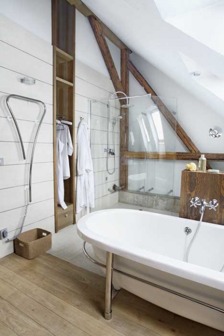 Łazienka pod skośnym sufitem z drewnianymi surowymi belkami