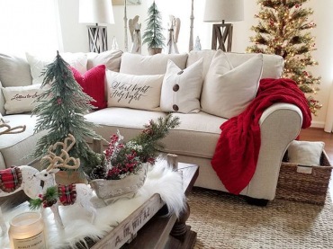 Świąteczna aranżacja salonu skupiła się wokół sofy. Czerwony pled i poduszki ze świąteczną typografią świetnie wpisują...