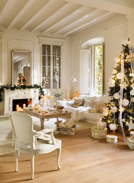 Biały francuski kominek w światecznej aranzacji salonu z tradycyjną choinką w białej dekoracji