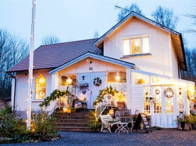 Świąteczne zielone girlandy,zielone wianki z lampkami i choinki w świątecznej aranżacji białego domku w stylu skandynawskim (27502)