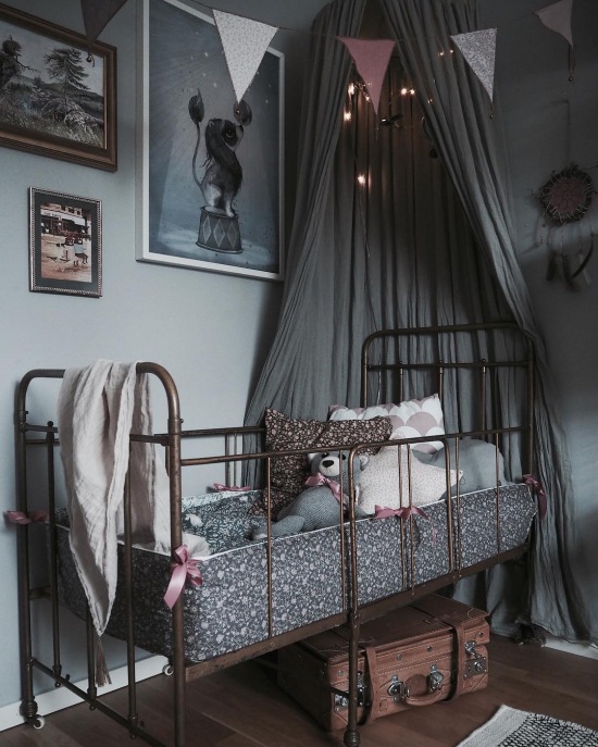 Złote łóżeczko z szarym baldachimem w pokoju dziecięcym
