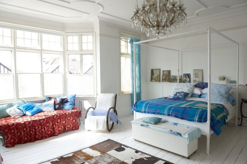 Biała sypialnia z wykuszem i turkusowymi zasłonami i narzutą