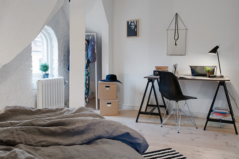 Sypialnia na poddaszu z białej cegły i z nowoczesnym biurkiem z drewna