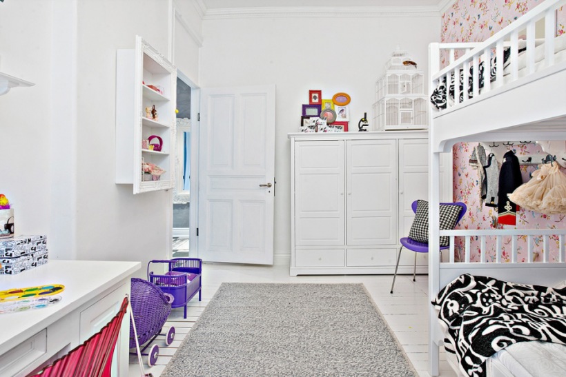 Białe mebelki dla dzieci,fioletowe krzesła i detale,szary dywanik i różowa tapeta dziecięca