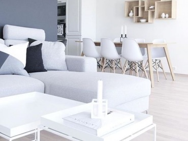 Połączenie bieli i drewna zawsze prezentuje się niezwykle świeżo i przyjemnie. Do salonu wybrano prostą szarą sofę w...