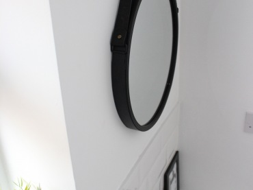 Czarne lustro o okrągłym kształcie zdecydowanie ozdabia łazienkową przestrzeń. W aranżacji warto także zwrócić uwagę na...