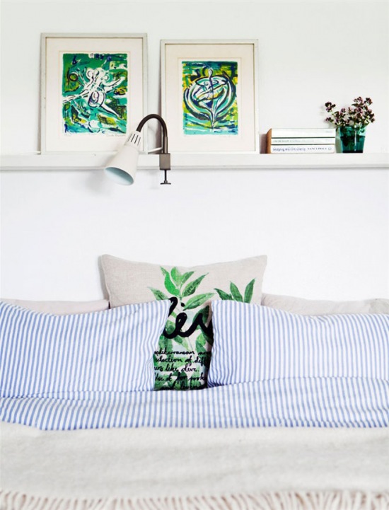 Roślinne zielone wzory na poduszkach i obrazach w białej sypialni