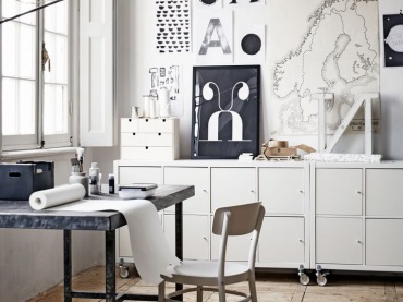 Białe komody na kółkach,czarno-białe grafiki w stylu skandynawskim,metalowe biurko i czarna lampa z wysięgnikiem w domowym biurze (24841)