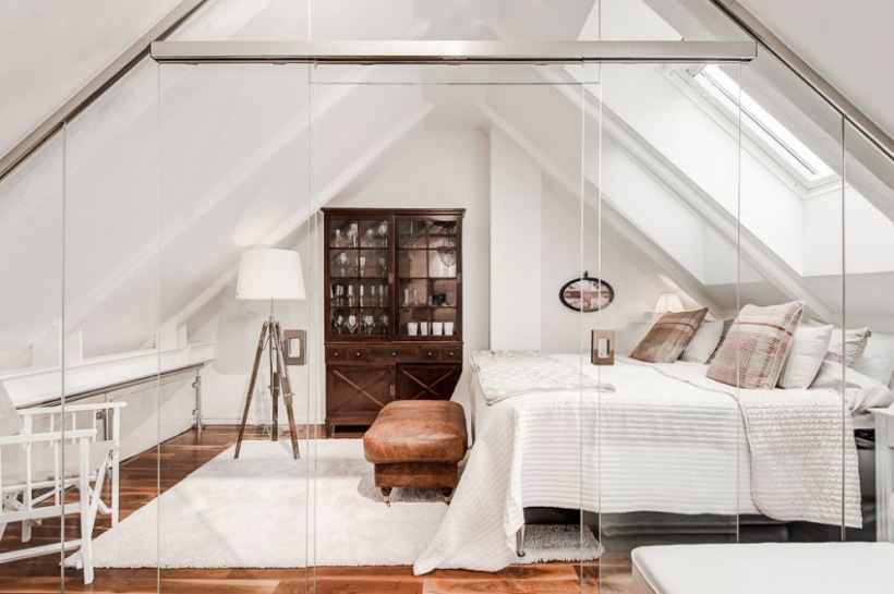 Elegancka biała sypialnia z lampą na trójnogu,klasyczną witryną i skórzanym pufem