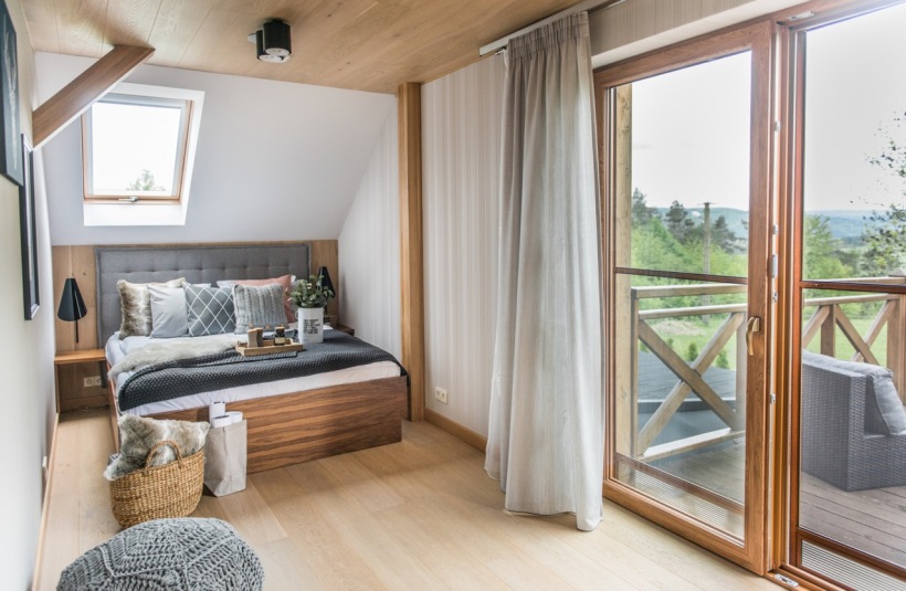 Mała sypialnia na poddaszu z drewnianym tarasem