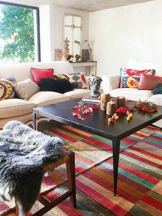 Kolorowe poduszki i tkane dywany w salonie w hiszpańskim wystroju
