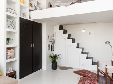 Biało-czarne schody  na antresole z łóżkiem  z wbudowanymi schowkami  w salonie  , czarna szafa wbudowana w ścianę z półkami (26089)