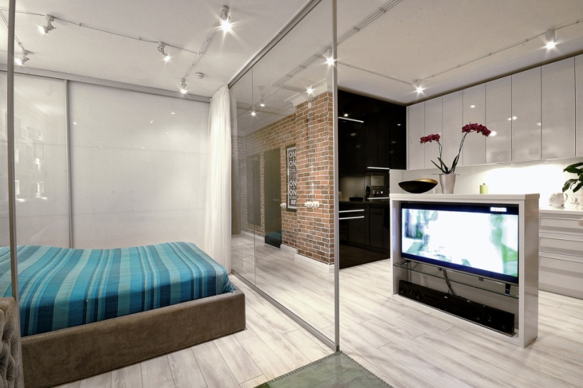 Sypialnia w otwartej zabudowie mieszkania oddzielona szklaną ścianką