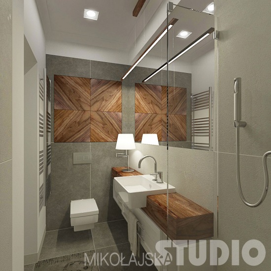 Szary betonowy gres na ścianie i podłodze w łazience z drewnianymi dekorami i blatem szafki z umywalką