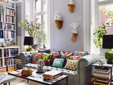 Błękitne ściany, sofa chesterfield pełna poduszek, industrialny stół i dodatki vintage - cudowny salon.