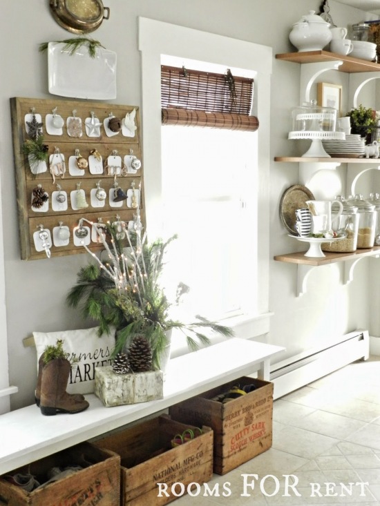 Adwentowy kalendarz,bambusowe roletty na oknie,drewniane półki z porcelaną w wiejskiej rustykalnbej kuchni w białym kolorze