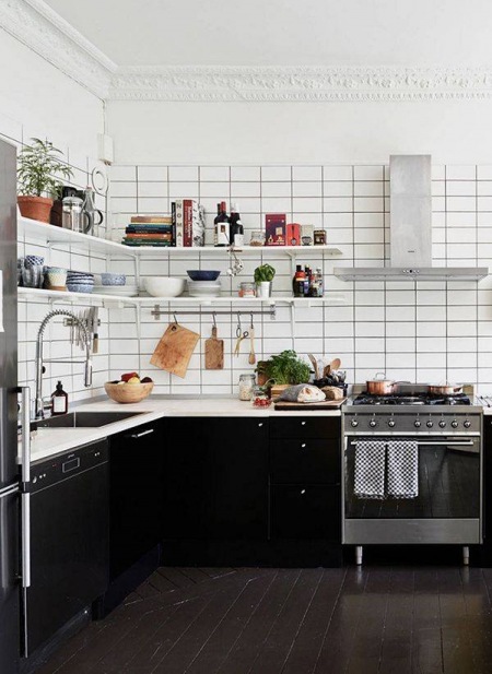 Biała glazurowane płytki na scianie w kuchni z czarnymi szafkami w skandynawskiej kuchni