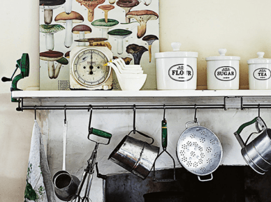 Porcelanowe pojemniki z przyprawami,okrągły zegar i kuchenne akcesoria przy wiejskim kominku (24161)