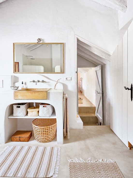 Biała łazienka z dodatkami w drewnie i wiklinie
