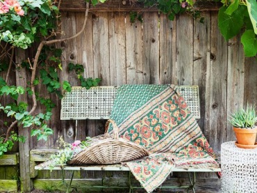 Stare drewniane deski i metalowa ławeczka towrzą sielską atmosferę w ogrodzie.