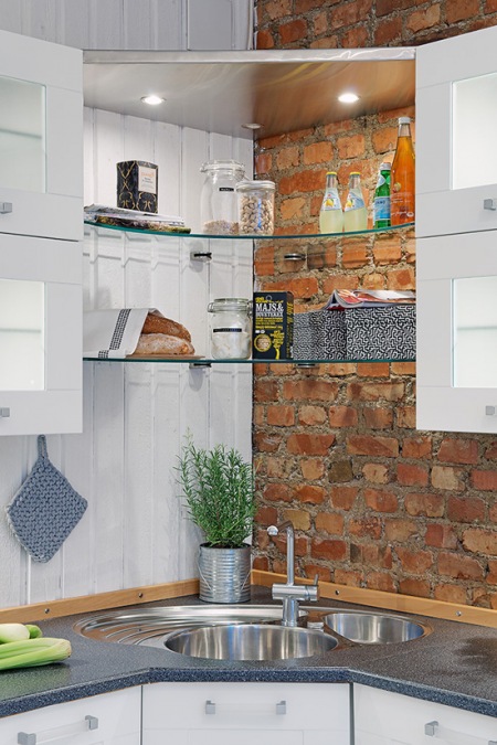Pomysł na szklaną półkę narożnikową w kuchni na ścianie z białej boazerii i cegły
