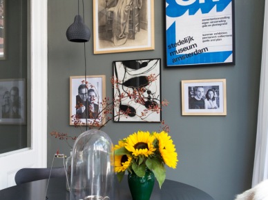 Szara ściana ,czarne wiszące lampy w nowoczesnym stylu,nowoczesne grafiki i fotogeafie retro na szarej ścianie,czarny okragły stolik (26360)