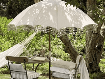 romantyczny obrazek ogrodu - lato w pełni,żar, cień parasola zabujany hamak - pełnia...