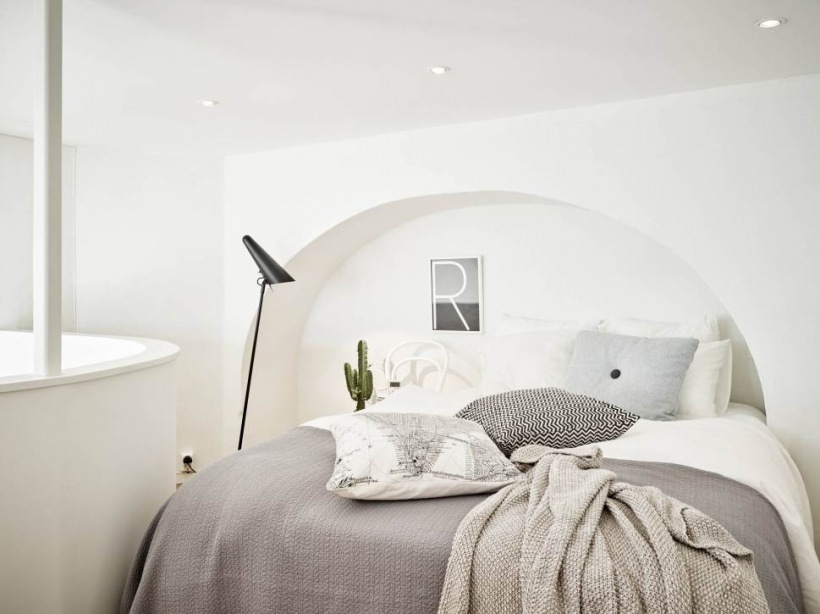 Biała sypialnia na nietypowej antresoli z łukowaną wnęką i ścianką