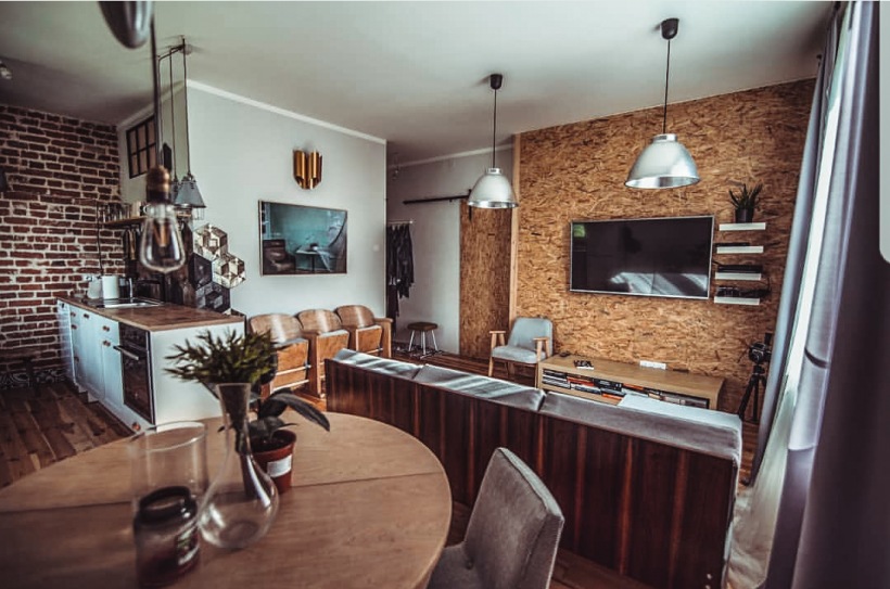 Eklektyczny salon z jadalnią z drewnem i czerwonymi cegłami