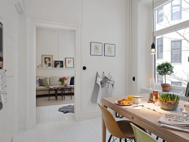 W białej kuchni urządzonej w skandynawskim stylu wygospodarowano miejsce na jadalnię. Drewniany stół podkreśla...