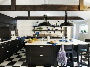 bardzo oryginalna kuchnia - czarne meble kuchenne wspaniale prezentują się na tle białych ścian i czarno-białej posadzce, ułożonej w karo. Niebieskie, ciemne dodatki dodają wnętrzu ekspresji i kolorytu. Ciekawa i piękna kuchnia, na dodatek...