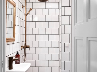 Białe kwadratowe kafeki na ścianie, czarne sześciokątne na posadzce w łazience z miedzianym prysznicem retro (24882)