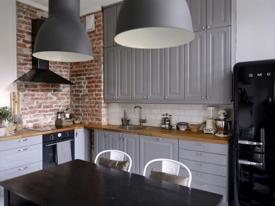 Czarny okap i lampy pendant w aranzacji szarej kuchni ze ścianą z czerwonej cegły (23947)