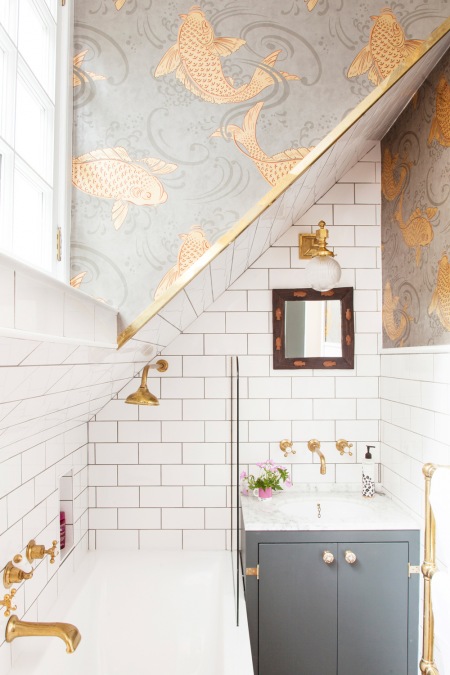 Oryginalna tapeta ze złotymi rybami w małej łazience na poddaszu