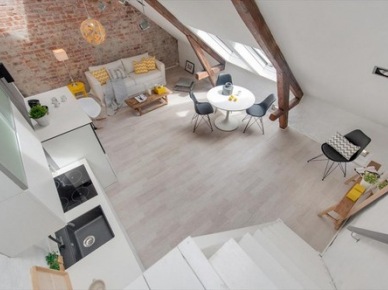 Poddasze w otwartym widoku salonu z kuchnią ze ścianą z cegły i podłogą z naturalnych desek (24581)