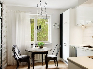 Stylowy stół okrągły,lampy przemyslowe na kablu,regał i krzesła metalowe TOLIX w białej kuchni skandynawskiej (23786)
