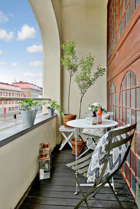 Miedziane lampiony i metalowe meble na małym balkonie